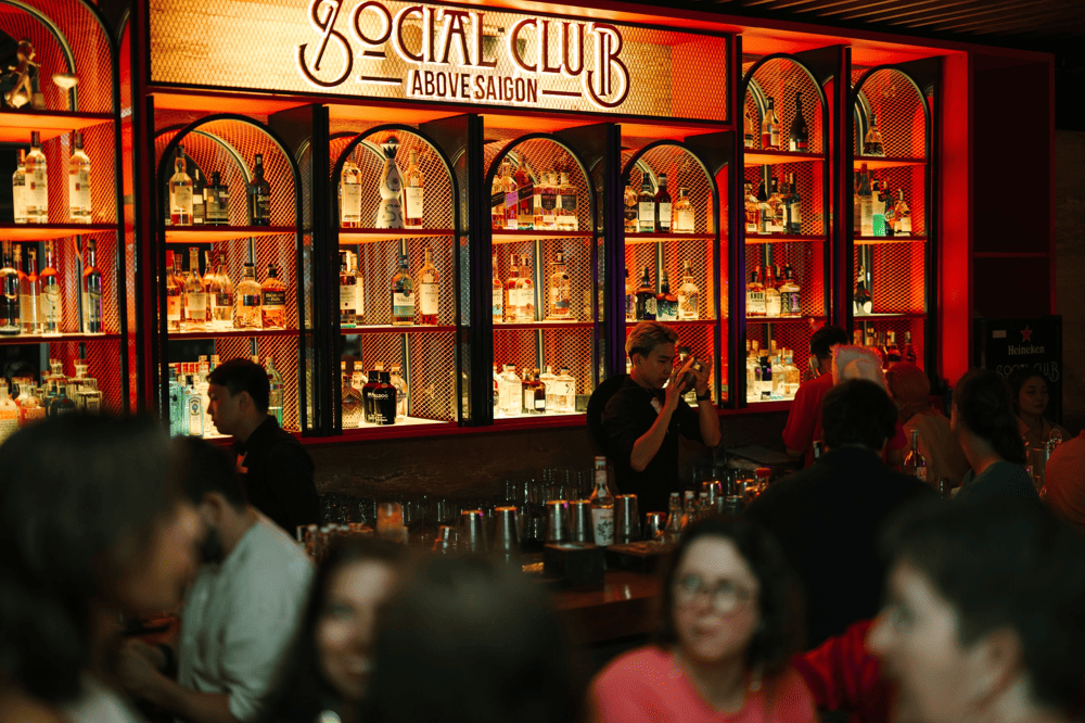 The glowing gold-lit bar invites guests to watch the finesse of skilled bartenders up close (Source: Social Club Rooftop Bar)